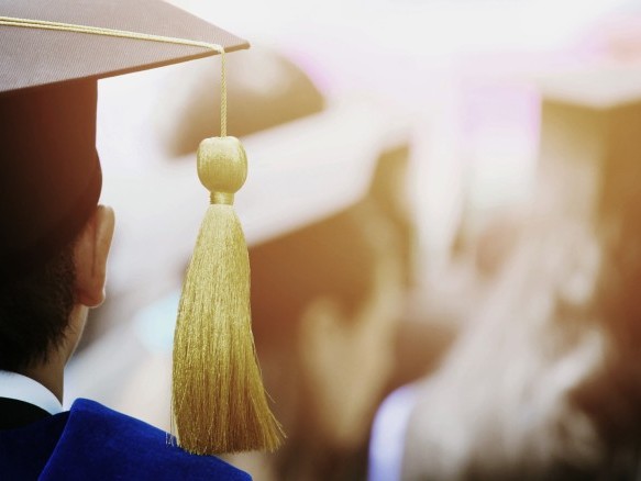 Junger Mann mit viereckigem Diplomhut mit einer Quaste