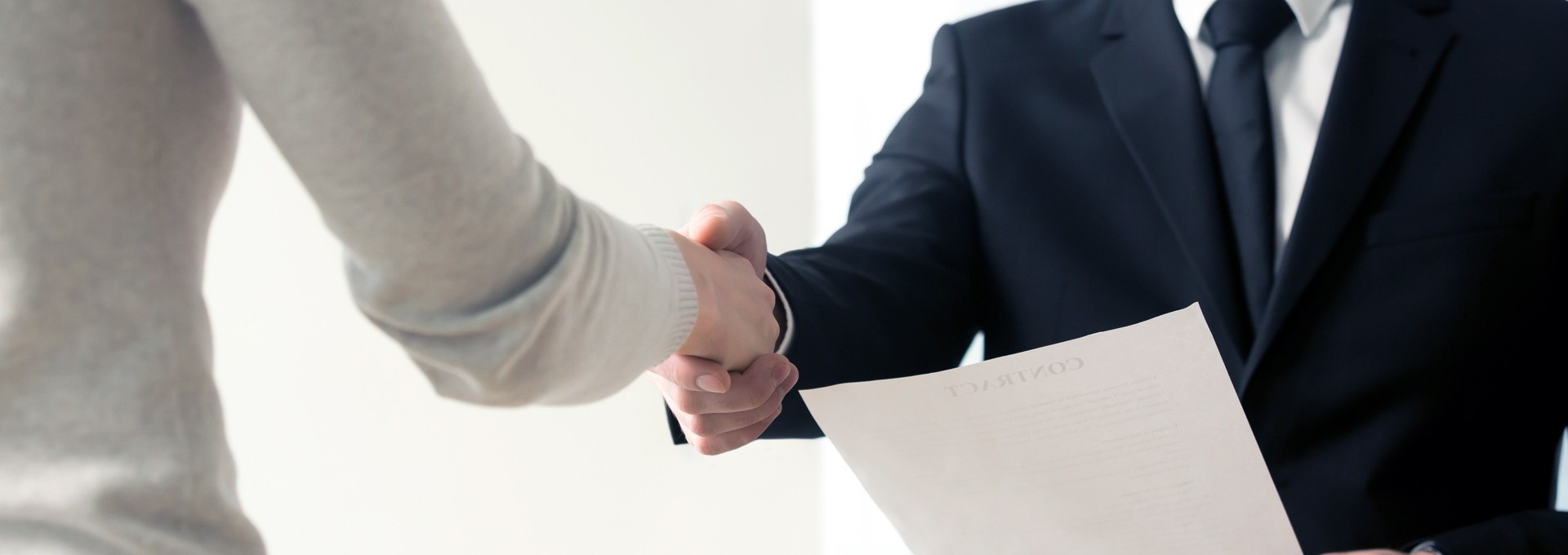 Händedruck beim Vorstellungsgespräch mit Unterlagen 