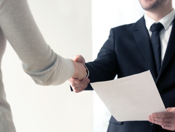 Handshake at a job interview with documents 