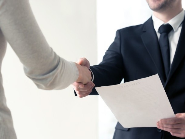Handshake at a job interview with documents 