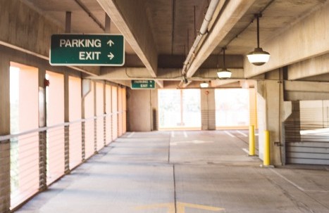 Empty parking garage with direction signs.