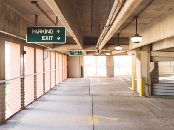 Leere Parkgarage mit Wegweisern.