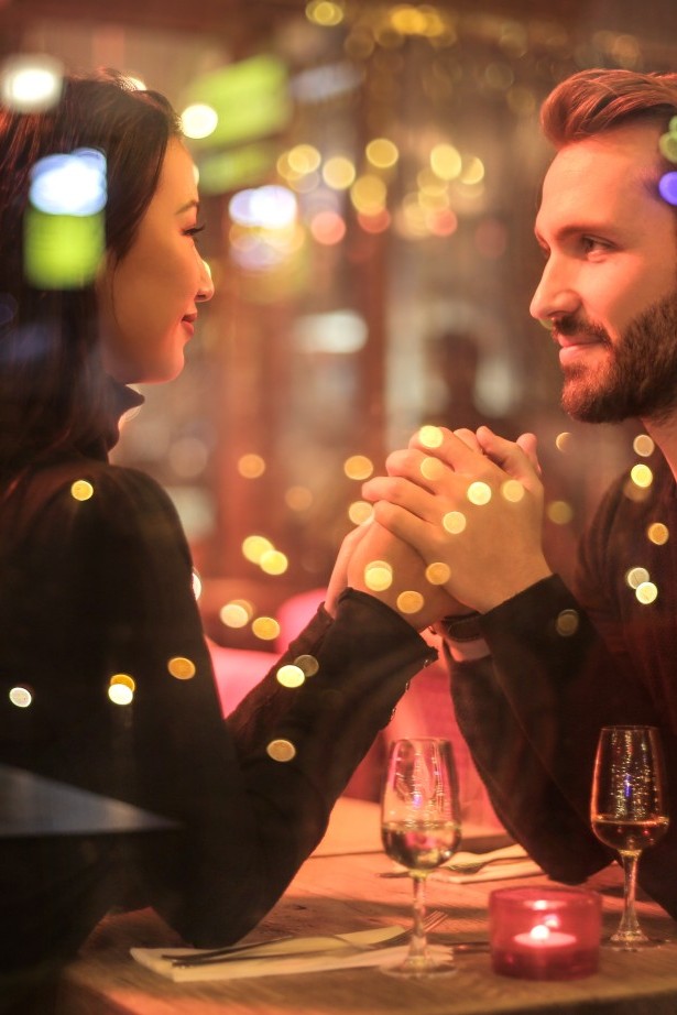 Ein Mann und eine Frau sitzen bei einem romantischen Candle-Light-Dinner.