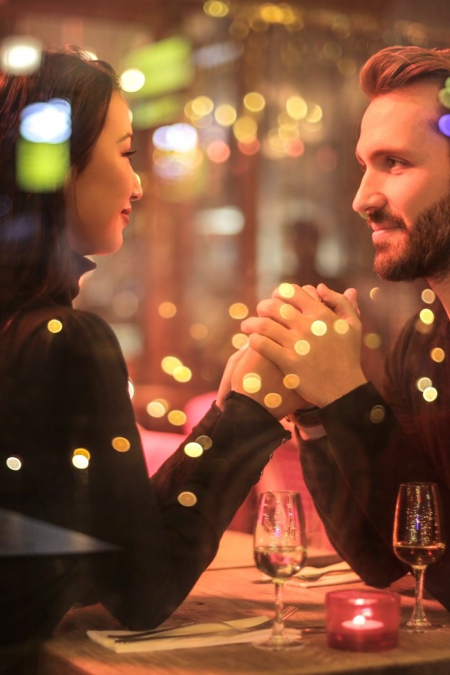 Ein Mann und eine Frau sitzen bei einem romantischen Candle-Light-Dinner.