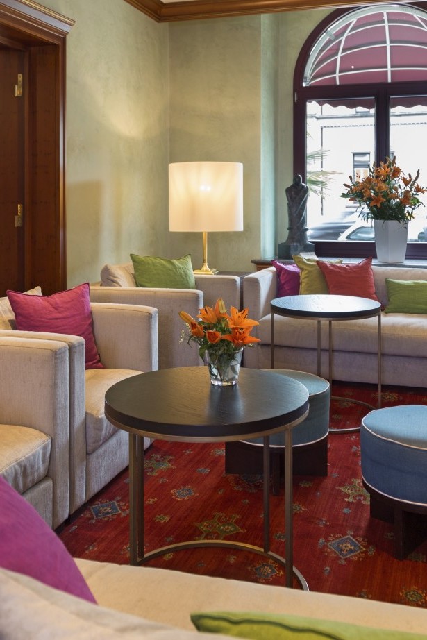 Cozy lounge with sofas by the window facing the sunny south side with fresh flowers.