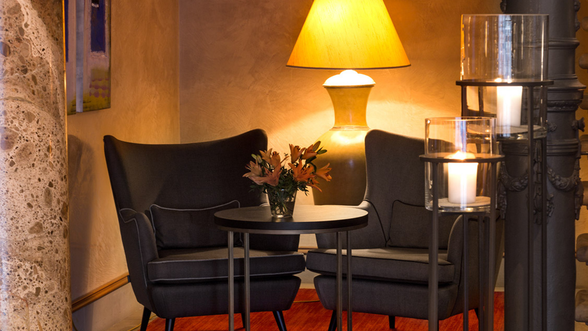 Cozy seating corner with nostalgic standing lamp and fresh flowers.