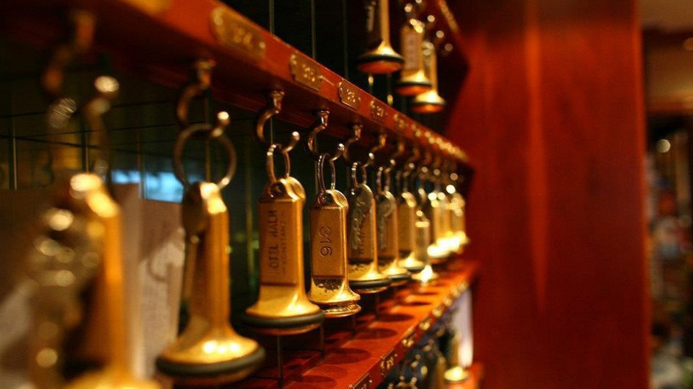 Reception wall with room shelves and hanging room keys with gold charms.