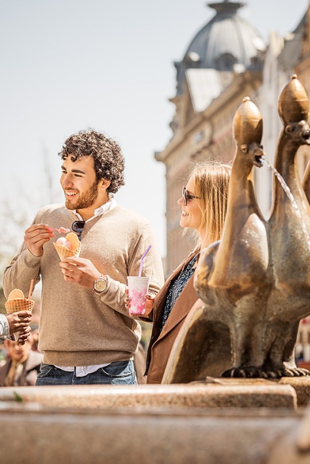 Drei Personen stehen beisammen und unterhalten sich an der Marktstätte im Zentrum von Konstanz