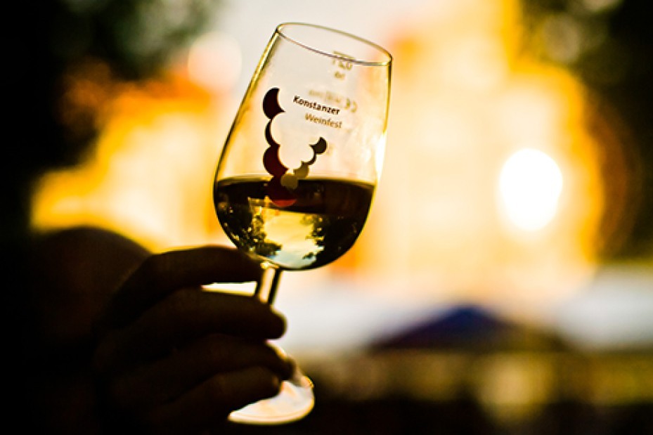 Nahaufnahme eines Glases mit Weisswein vor unscharfem Hintergrund